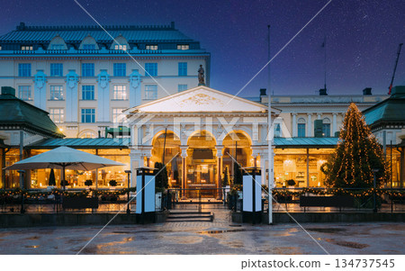 Helsinki, Finland. Famous And Popular Place Is Cafe, Bar, Restaurant On Esplanadi Park In Lighting At Evening Or Night Illumination. Night stars shining above street Helsinki, Finland. Famous And Popular Place Is Cafe, Bar, Restaurant On Esplanadi Park In Lighting At Evening Or Night Illumination. Night stars shining above street 134737545