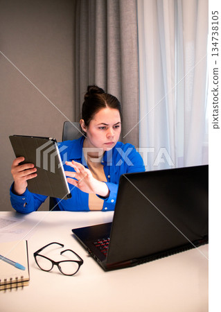 Online business owner managing her e-commerce store from home. Entrepreneur analyzes data on computer screen in home setting. Modern reality of running successful digital business remotely Online business owner managing her e-commerce store from home. Entrepreneur analyzes data on computer screen in home setting. Modern reality of running successful digital business remotely 134738105