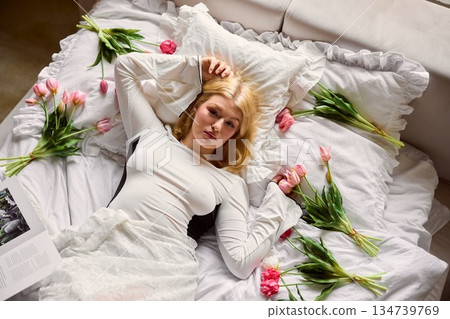 Pink tulip scene, Gentle scene of woman resting amid sea of blooming tulips in warm daylight Pink tulip scene, Gentle scene of woman resting amid sea of blooming tulips in warm daylight 134739769
