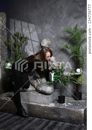 Peaceful scene of woman caring for her potted plant collection indoors 134739777
