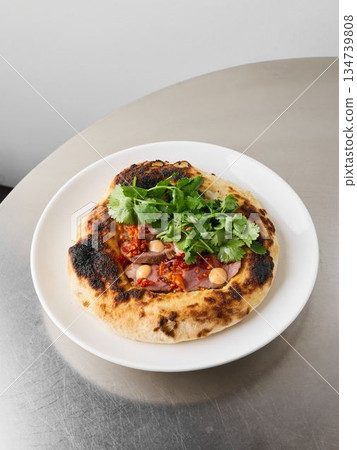 Handheld pizza featuring burnt marks and gooey cheese layers 134739808