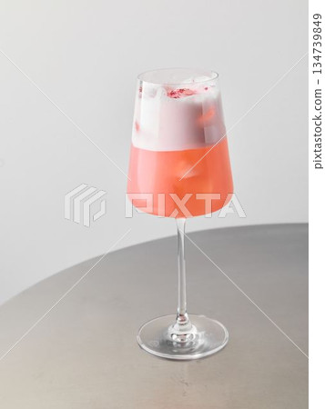 Chic layered mocktail featuring white foam and blush sprinkles Chic layered mocktail featuring white foam and blush sprinkles 134739849