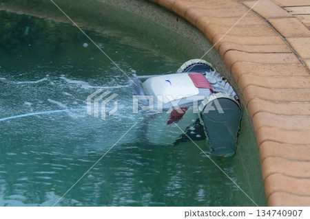 A swimming pool cleaning robot in action in a domestic pool A swimming pool cleaning robot in action in a domestic pool 134740907