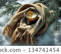 Candle placed on a knitted scarf surrounded by snow and pine branches during winter 134741454