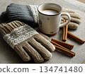 Warm gloves and coffee mug with cinnamon sticks on a cozy table setting in winter 134741480