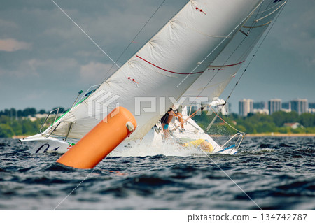 Sailing regatta in the Gulf of Finland at sunny day, sailing yacht competing in a race, splashing water from under the boat, teamwork, board the boat 134742787