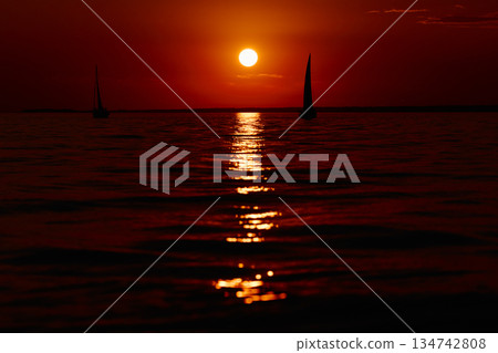 Sailing regatta in the Gulf of Finland at sunset, few sailing yachts competing in a race, splashing water from under the boats, teamwork, board the boat Sailing regatta in the Gulf of Finland at sunset, few sailing yachts competing in a race, splashing water from under the boats, teamwork, board the boat 134742808