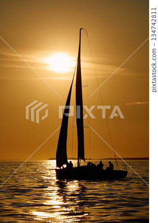 Sailing regatta in the Gulf of Finland at sunset, few sailing yachts competing in a race, splashing water from under the boats, teamwork, board the boat Sailing regatta in the Gulf of Finland at sunset, few sailing yachts competing in a race, splashing water from under the boats, teamwork, board the boat 134742811