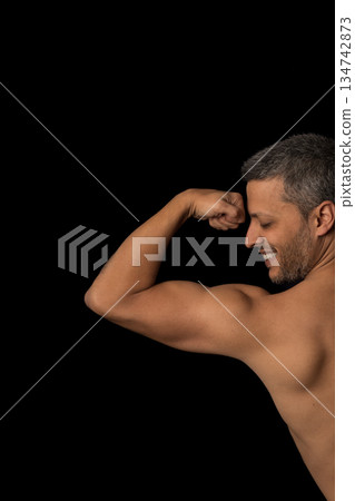 A man with a muscular arm flexes his arm A man with a muscular arm flexes his arm 134742873