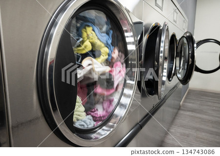 Modern Self-Service Laundromat with Industrial Washing Machines 134743086