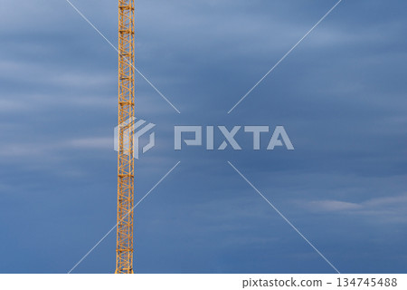 Tower of construction crane on the background of the sky before the storm. Construction technologies Tower of construction crane on the background of the sky before the storm. Construction technologies 134745488