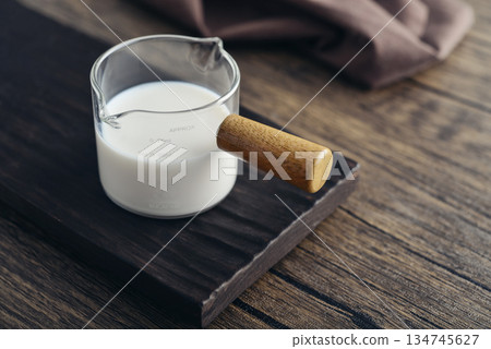 Milk in measuring glass cup Milk in measuring glass cup 134745627