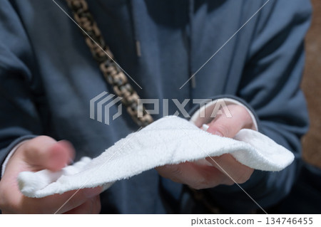 A person wiping their hands with a wet towel 134746455