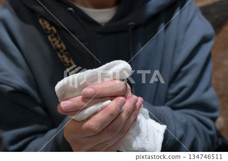 A person wiping their hands with a wet towel A person wiping their hands with a wet towel 134746511