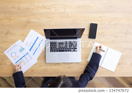 Aerial view of a woman doing desk work Aerial view of a woman doing desk work 134747672