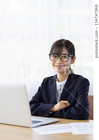 Young woman in a suit smiling at the camera Young woman in a suit smiling at the camera 134747868