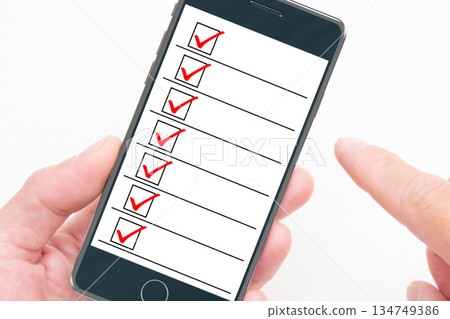 A person checking a list on their smartphone A person checking a list on their smartphone 134749386