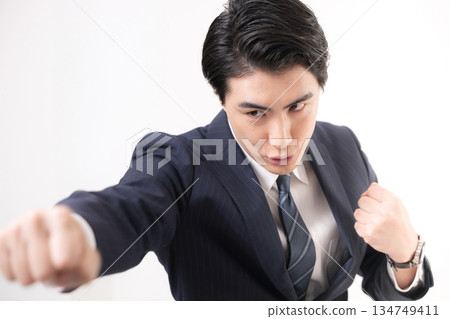 一位身穿西裝的商人揮舞著拳頭,展現他的勝利、成功以及為挑戰而戰的精神。 一位身穿西裝的商人揮舞著拳頭,展現他的勝利、成功以及為挑戰而戰的精神。 134749411