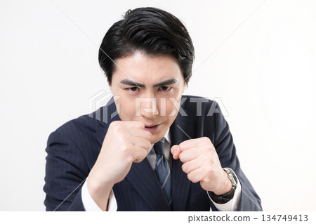 A businessman in a suit pumping his fist in a fist pump, showing his victory, success, and fighting for a challenge A businessman in a suit pumping his fist in a fist pump, showing his victory, success, and fighting for a challenge 134749413