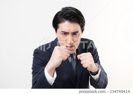 一位身穿西裝的商人揮舞著拳頭，展現他的勝利、成功以及為挑戰而戰的精神。 134749414