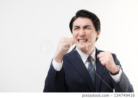 一位身穿西裝的商人揮舞著拳頭,展現他的勝利、成功以及為挑戰而戰的精神。 一位身穿西裝的商人揮舞著拳頭,展現他的勝利、成功以及為挑戰而戰的精神。 134749416