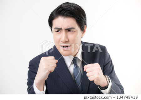 A businessman in a suit pumping his fist in a fist pump, showing his victory, success, and fighting for a challenge A businessman in a suit pumping his fist in a fist pump, showing his victory, success, and fighting for a challenge 134749419
