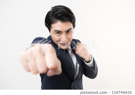 A businessman in a suit pumping his fist in a fist pump, showing his victory, success, and fighting for a challenge 134749420