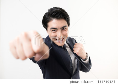 一位身穿西裝的商人揮舞著拳頭,展現他的勝利、成功以及為挑戰而戰的精神。 一位身穿西裝的商人揮舞著拳頭,展現他的勝利、成功以及為挑戰而戰的精神。 134749421