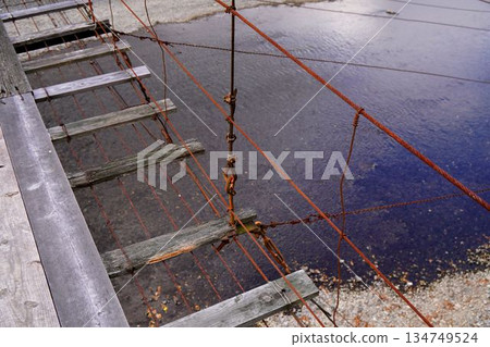 Crossing a dilapidated suspension bridge 134749524