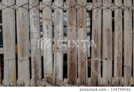Weathered bamboo fence showing natural texture, knots, and muted color palette ideal for rustic design backdrops and eco-friendly themed projects 134749582