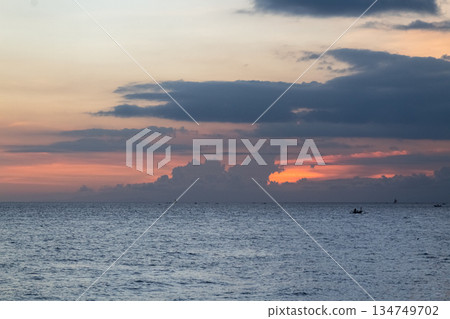 Calm Sea at Sunset with Dramatic Clouds and Golden Light Reflecting on the Water, Providing Ample Copy Space for Inspirational Messages Calm Sea at Sunset with Dramatic Clouds and Golden Light Reflecting on the Water, Providing Ample Copy Space for Inspirational Messages 134749702