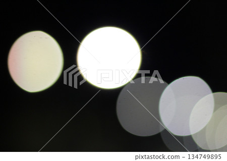 Blurred Light Orbs Floating in Darkness Creating Bokeh Effect for Backgrounds and Textures Blurred Light Orbs Floating in Darkness Creating Bokeh Effect for Backgrounds and Textures 134749895