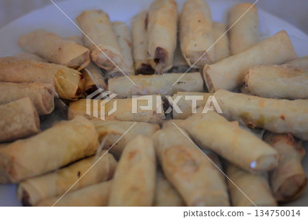 Pile of Fresh Spring Rolls Appetizers Displaying Golden Wrappers in Natural Light for Snack or Side Dish on White Background 134750014