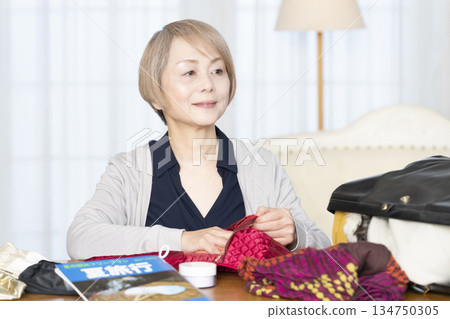 老婦人在客廳收拾行李準備旅行 134750305