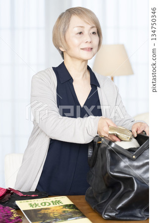 老婦人在客廳收拾行李準備旅行 134750346