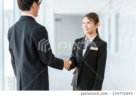 Businessmen and women shaking hands in a corporate office to greet, introduce themselves and conclude a contract 134750943