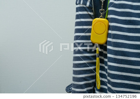A yellow security alarm attached to a school bag 134752196