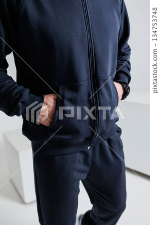 A man in a black jacket and pants has hands in pockets A man in a black jacket and pants has hands in pockets 134753748