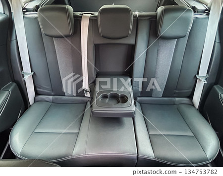 Experience unmatched luxury in the back seat of a modern vehicle, featuring plush leather upholstery and a welldesigned armrest for maximum comfort and style during every adventure 134753782