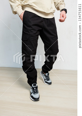 Explore the latest collection of trendy black cargo pants that are perfectly matched with stylish sneakers, making them ideal for a modern casual look that truly stands out in todays fashion scene 134753811