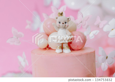 This pink birthday cake features a cute teddybear figurine, colorful balloons, and beautiful butterflies, perfect for any joyful celebration or special occasion filled with sweetness and fun This pink birthday cake features a cute teddybear figurine, colorful balloons, and beautiful butterflies, perfect for any joyful celebration or special occasion filled with sweetness and fun 134753832