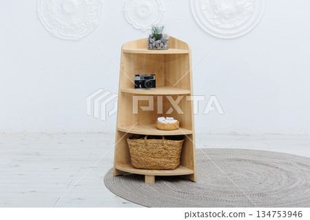 A wooden shelf that features a decorative basket on the bottom shelf A wooden shelf that features a decorative basket on the bottom shelf 134753946