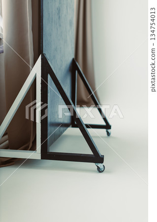 This sleek and modern mobile display stand features a minimalist design that complements any environment, complete with a sturdy triangular base for enhanced stability and aesthetic appeal 134754013