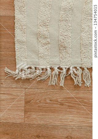 This soft textured area rug showcases beautifully fringed edges that span across a gorgeous wooden floor, making it perfect for adding warmth and comfort to enhance your living space beautifully 134754015