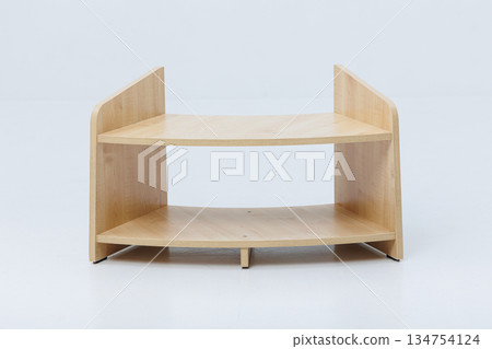 A wooden shelf with two levels set against a white background A wooden shelf with two levels set against a white background 134754124