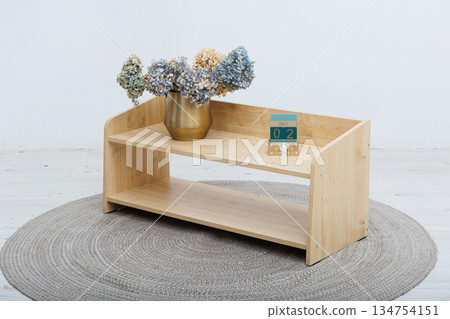 A beautifully crafted wooden shelf that showcases a lovely vase of flowers on it A beautifully crafted wooden shelf that showcases a lovely vase of flowers on it 134754151