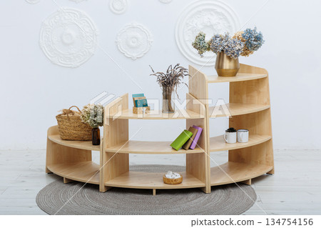 A wooden shelf with a lovely vase of flowers on top 134754156