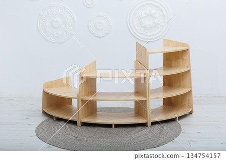 A beautifully curved wooden shelf elegantly sits on a soft rug in a cozy room 134754157