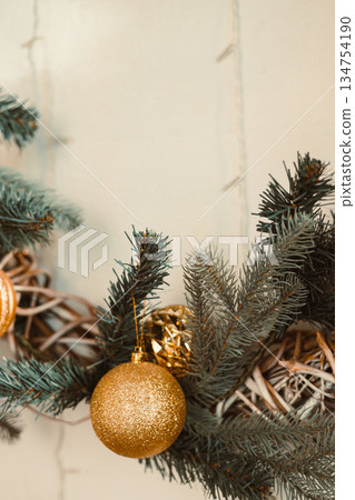 This beautifully crafted Christmas wreath, adorned with golden ornaments and fresh greenery, adds charm and elegance to your holiday decor, enhancing the festive spirit of the season This beautifully crafted Christmas wreath, adorned with golden ornaments and fresh greenery, adds charm and elegance to your holiday decor, enhancing the festive spirit of the season 134754190
