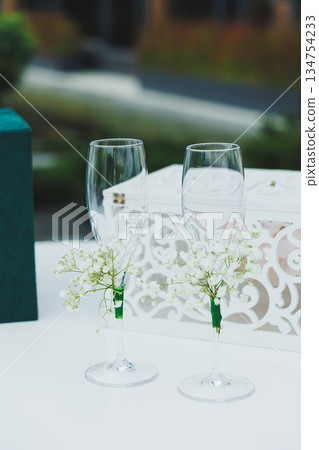 Sleek and Elegant Champagne Glasses Adorned with Beautiful Decorative Flowers for Your Enjoyment 134754233